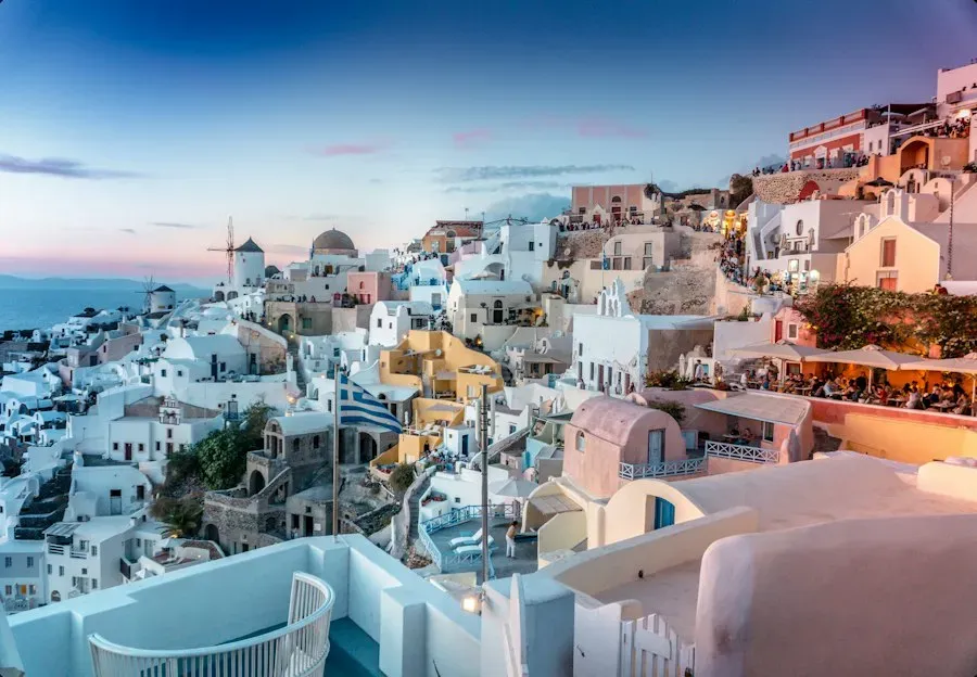 Whitewashed cliffside houses in Santorini at dusk
