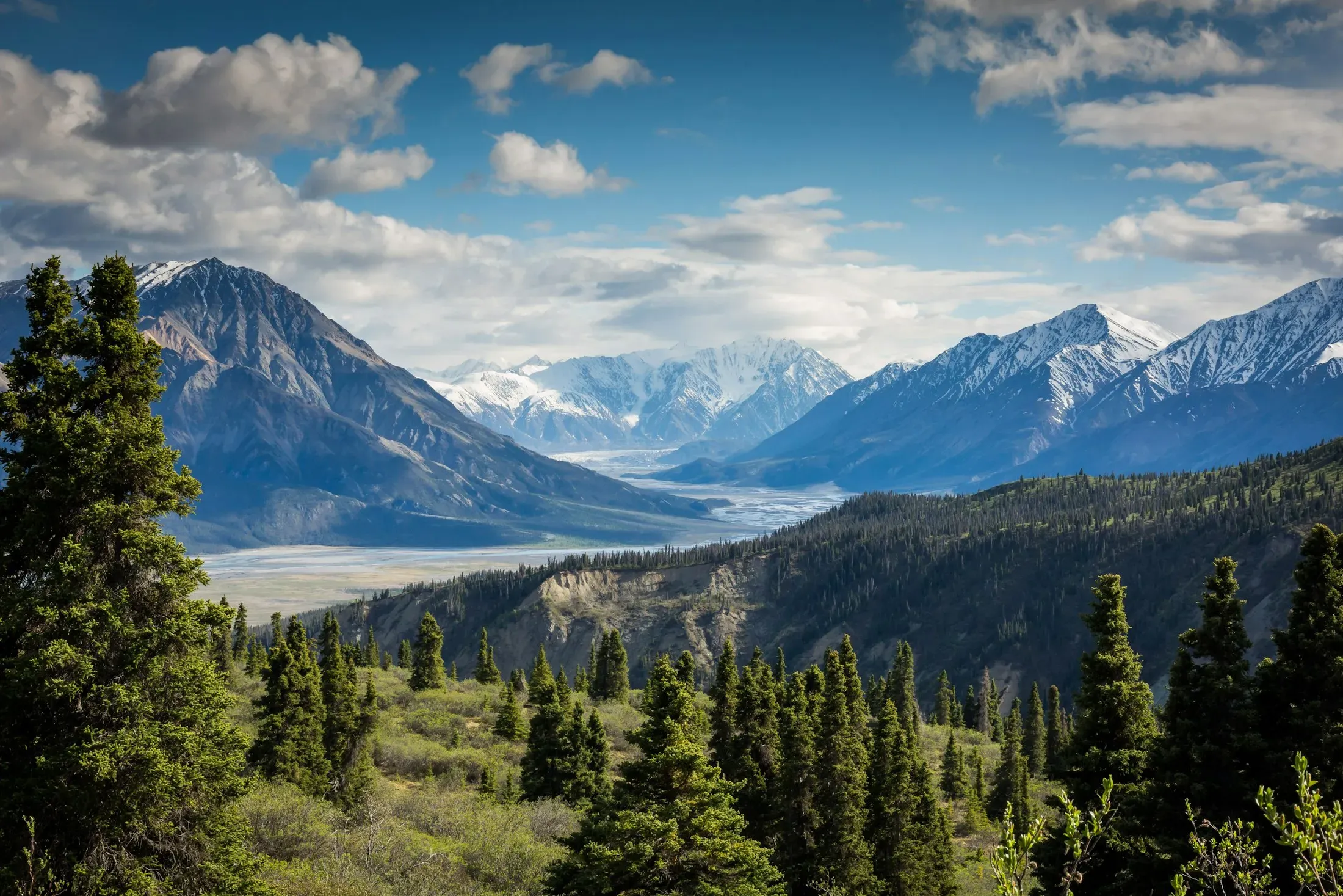 Aerial view of sunlit mountains above a quiet valley